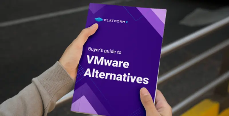 A photo of a person holding a booklet with a deep purple cover that has the text "Buyer’s guide to VMware Alternatives" on it